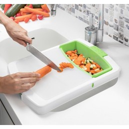 Une planche à découper extensible originale et polyvalente avec plateau amovible, passoire intégrée et récipient amovible pour placer les aliments ou les déchets.